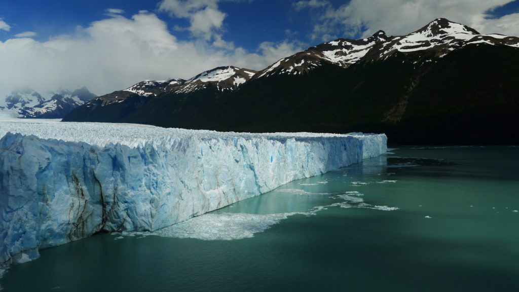 A picture of the Glacier under cloud cover with the mountains in the background