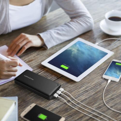 An image showing the best portable charger connected to multiple devices on a desk