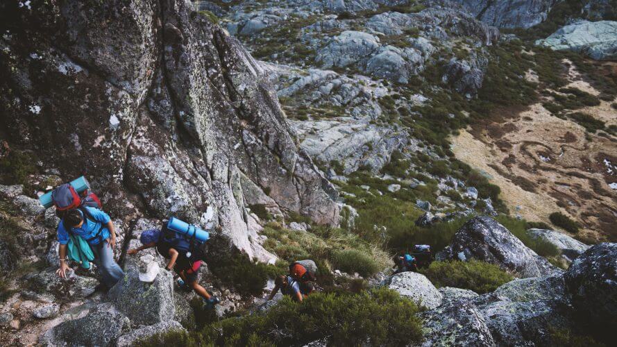 A group of trekkers climbing a steep mountain