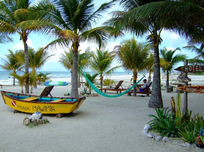 An image of hammocks and boats on the beach at Isla Holbox Mexico