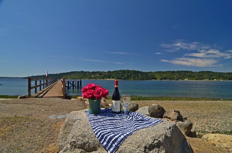 A setting featuring wine glasses facing the water at bainbridge island