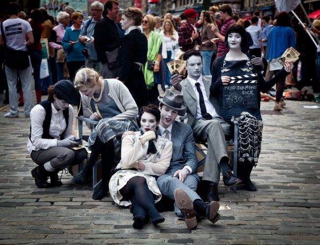 A group of street performers are seen posing in this picture