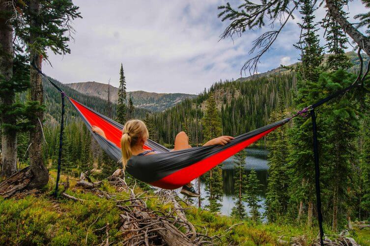 An image of a girl on a hammock overlooking a lake
