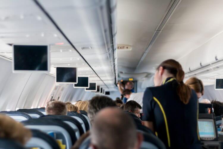 Flight attendants tending to passengers are shown here