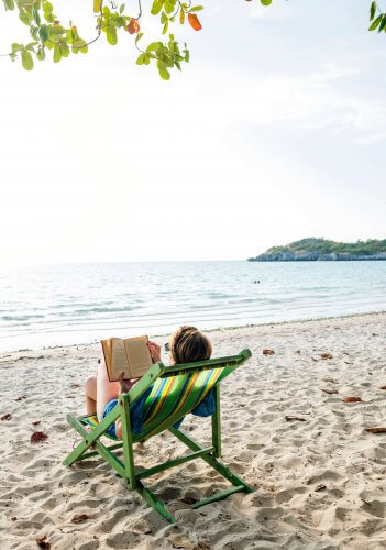 A person getting some reading done on the beach