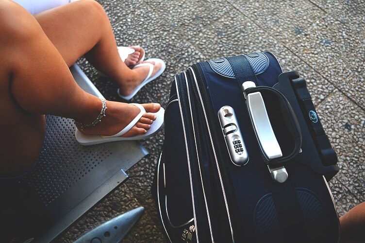 An image of a girl next to a suitcase