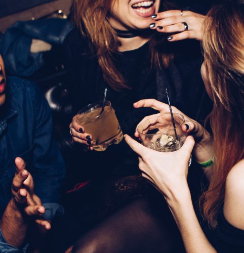 Women with drinks laughing at a party