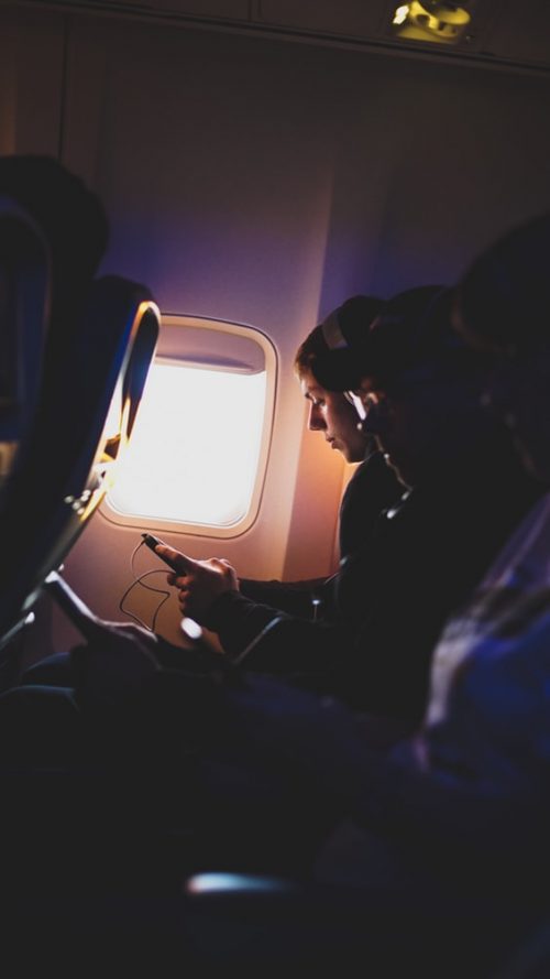 Woman using phone on a plane