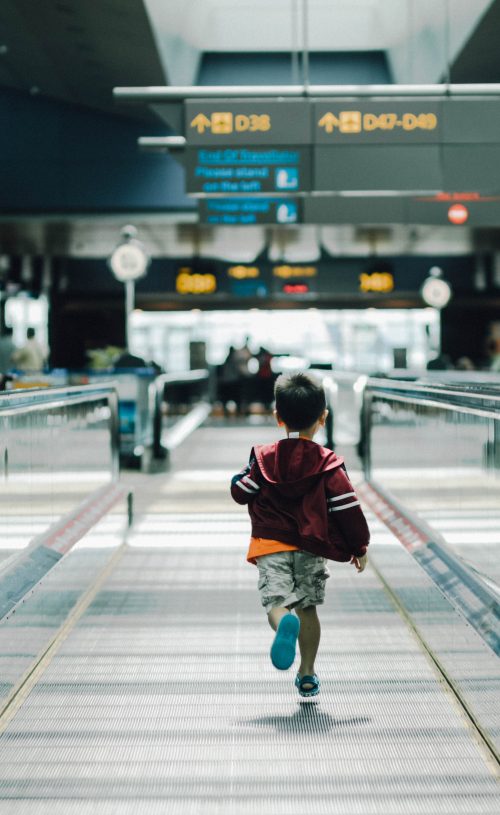 Child running along walkway in airport